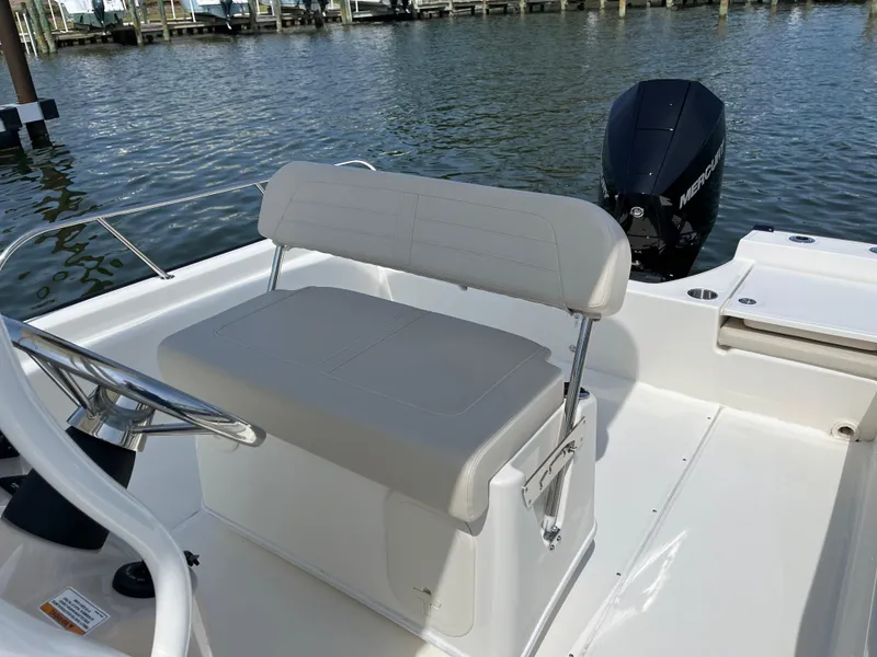 Slide: The Image of 2024 Boston Whaler 210 Montauk boat interior with seating and outboard motor. - 7