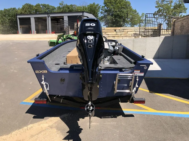 Slide: The Image of 2024 Alumacraft 165 Escape CS boat with a 50 HP outboard motor, parked on a trailer. - 6