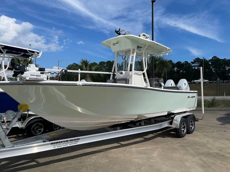 The Image of 2024 Sea Born LX 24 LE boat on a trailer under a clear blue sky. - 1