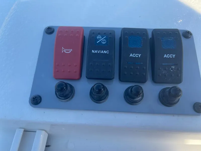 Slide: The Image of Control panel of 2024 Sea Born LX 24 LE boat with switches for horn, navigation, and accessories. - 17