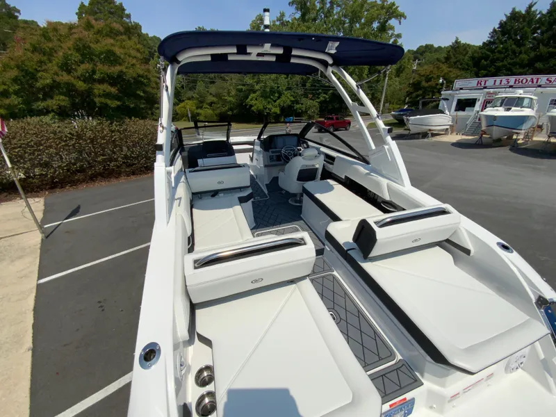 Slide: The Image of 2025 Cobalt R6 Outboard boat with spacious seating and modern design in a parking lot. - 12