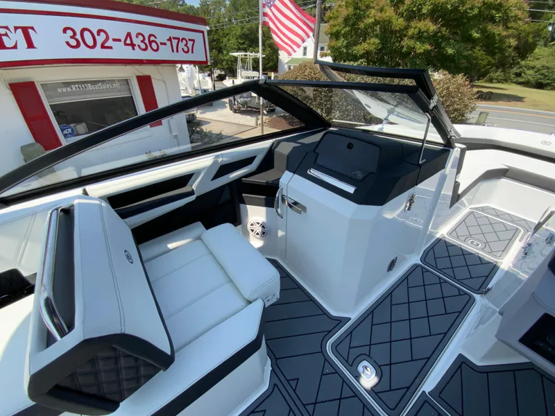 Slide: The Image of 2025 Cobalt R6 Outboard interior with modern seating and dashboard, American flag in background. - 16