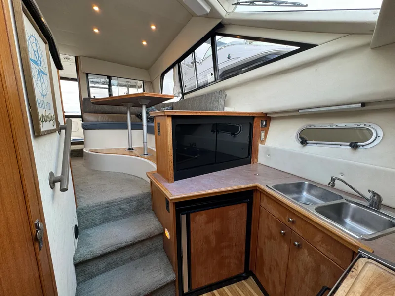Slide: The Image of Interior of 1996 Bayliner 3388 Command Bridge Motoryacht with kitchen and dining area. - 12