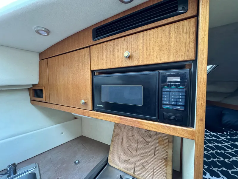 Slide: The Image of 1996 Bayliner 3388 Command Bridge Motoryacht kitchen with microwave and wooden cabinets. - 14