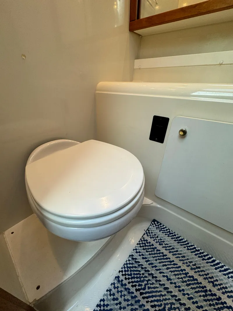 Slide: The Image of 1996 Bayliner 3388 Command Bridge Motoryacht bathroom with toilet and storage cabinet. - 17