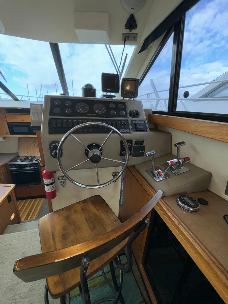 Slide: The Image of 1996 Bayliner 3388 Command Bridge Motoryacht helm with steering wheel and control panel. - 22