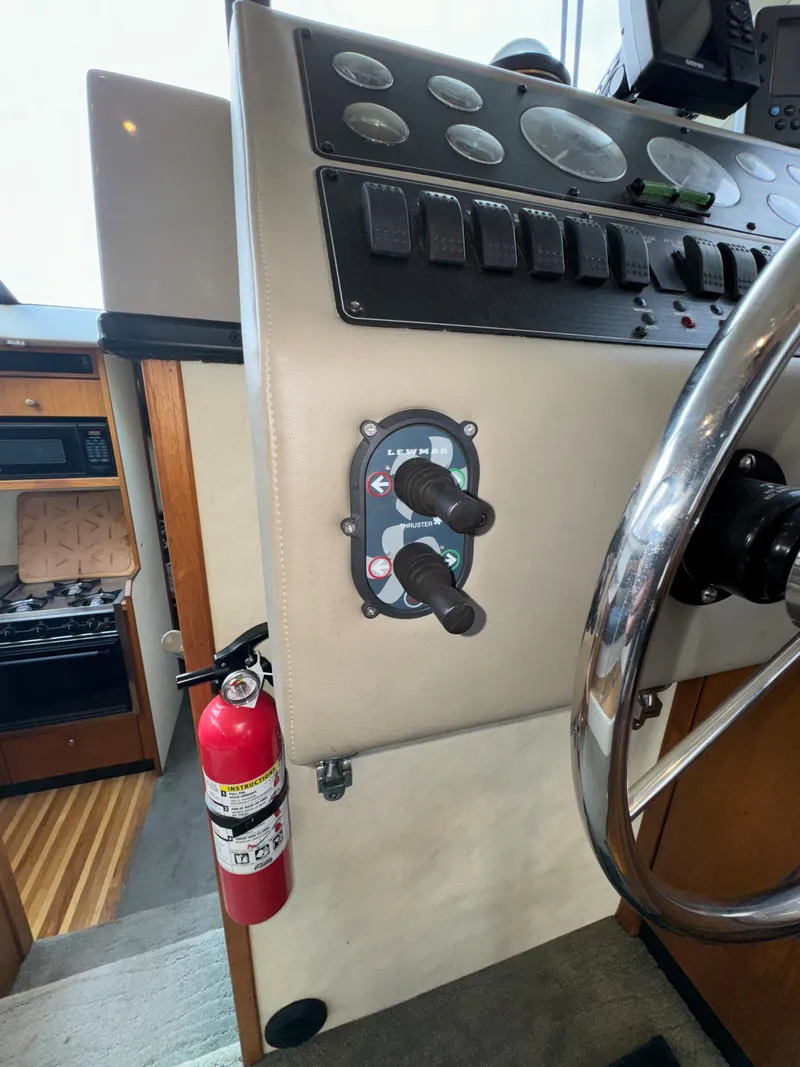 Slide: The Image of 1996 Bayliner 3388 Command Bridge Motoryacht helm with controls and fire extinguisher. - 24