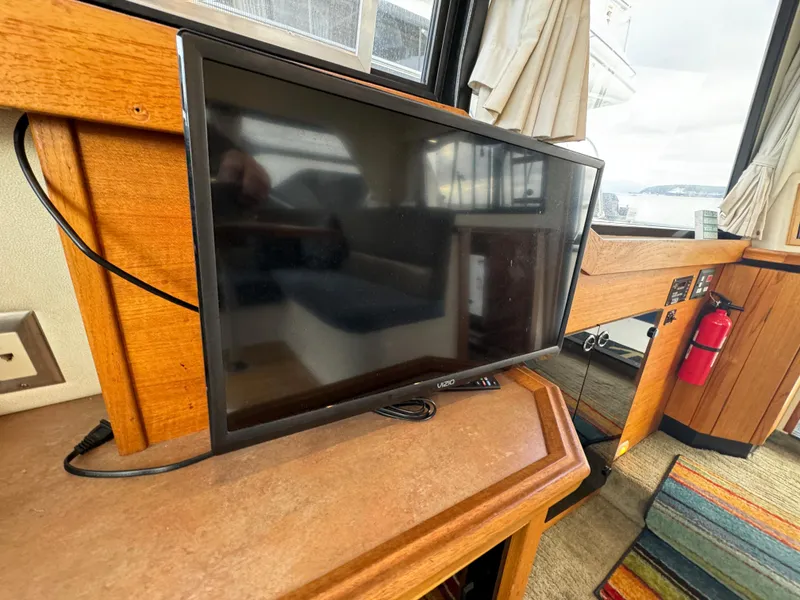 Slide: The Image of Flat-screen TV inside 1996 Bayliner 3388 Command Bridge Motoryacht, wooden interior, and window view. - 28