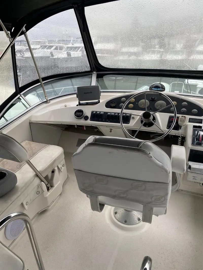 Slide: The Image of 1996 Bayliner 3388 Command Bridge Motoryacht helm with steering wheel and navigation controls. - 45