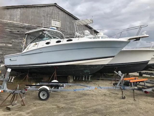 Slide: The Image of 2004 Wellcraft 330 Coastal boat on trailer, in front of barn. - 2