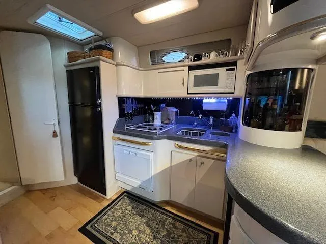 Slide: The Image of 1997 Sea Ray 500 Sundancer yacht kitchen with modern appliances and ample storage. - 17