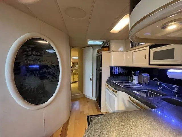 Slide: The Image of 1997 Sea Ray 500 Sundancer interior kitchen with modern amenities and stylish design. - 18