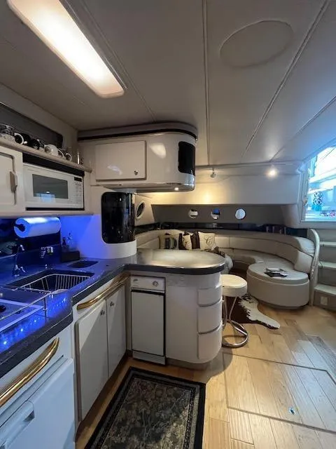 Slide: The Image of 1997 Sea Ray 500 Sundancer yacht interior with modern kitchen and cozy seating area. - 19