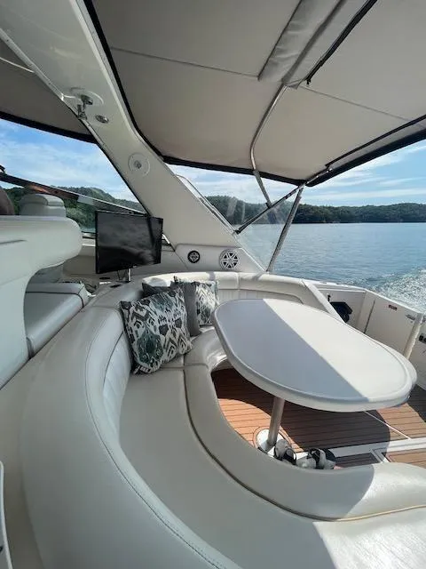 Slide: The Image of 1997 Sea Ray 500 Sundancer interior with seating and table on a sunny day. - 21