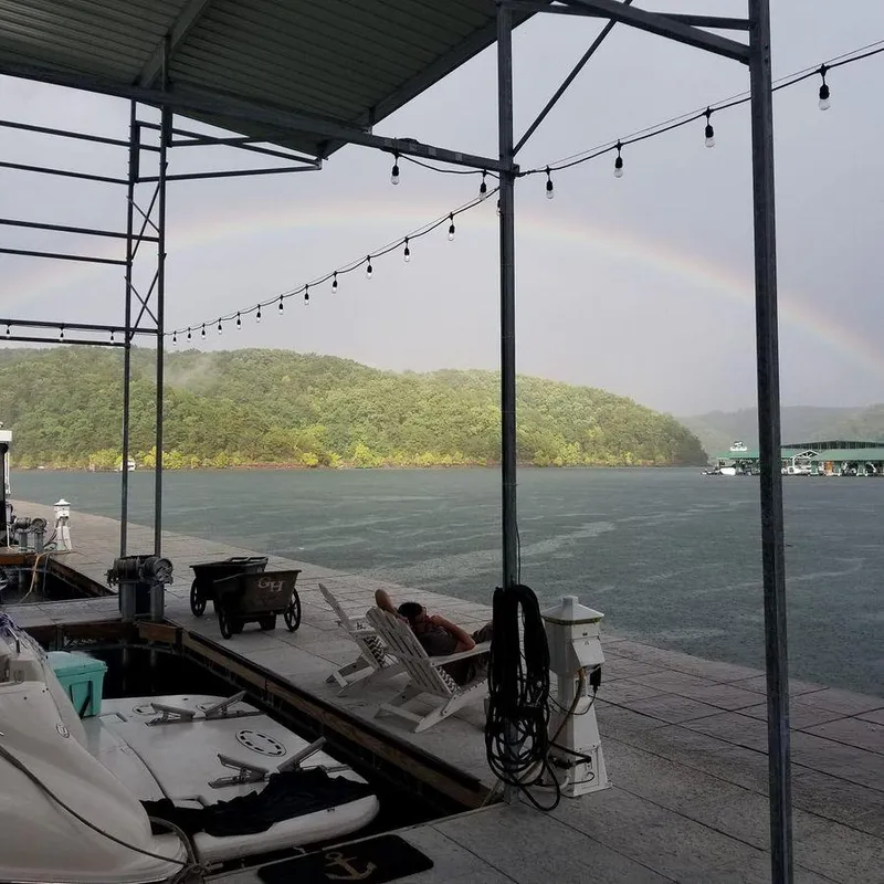 Slide: The Image of 1997 Sea Ray 500 Sundancer docked under a rainbow at a lakeside marina. - 28