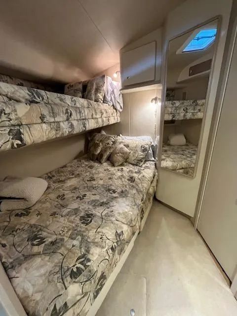 Slide: The Image of 1997 Sea Ray 500 Sundancer cabin with bunk beds and floral bedding. - 8