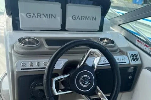 Slide: The Image of 2024 Crownline 270 CR boat dashboard with dual Garmin displays and steering wheel. - 10