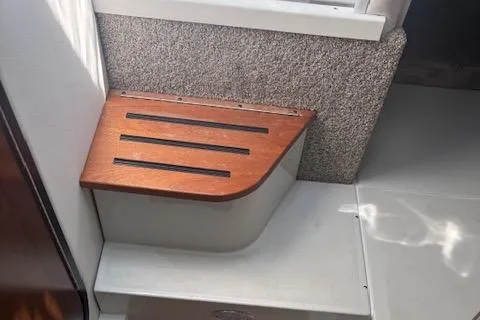 Slide: The Image of 2024 Crownline 270 CR interior step with wooden finish and textured wall. - 20