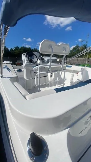 Slide: The Image of 2024 Tahoe 2150 CC boat interior with steering console and seating under blue sky. - 5