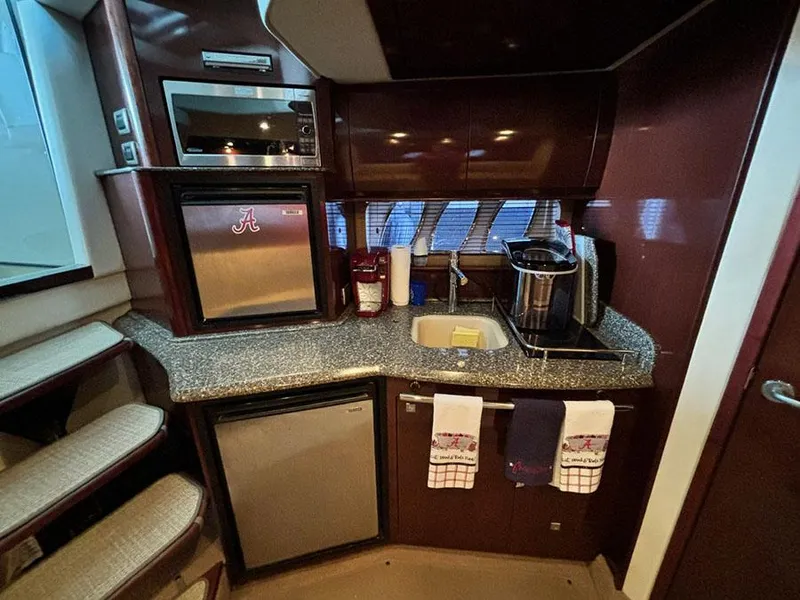 Slide: The Image of 2008 Sea Ray 38 Sundancer galley with microwave, fridge, sink, and countertop. - 21