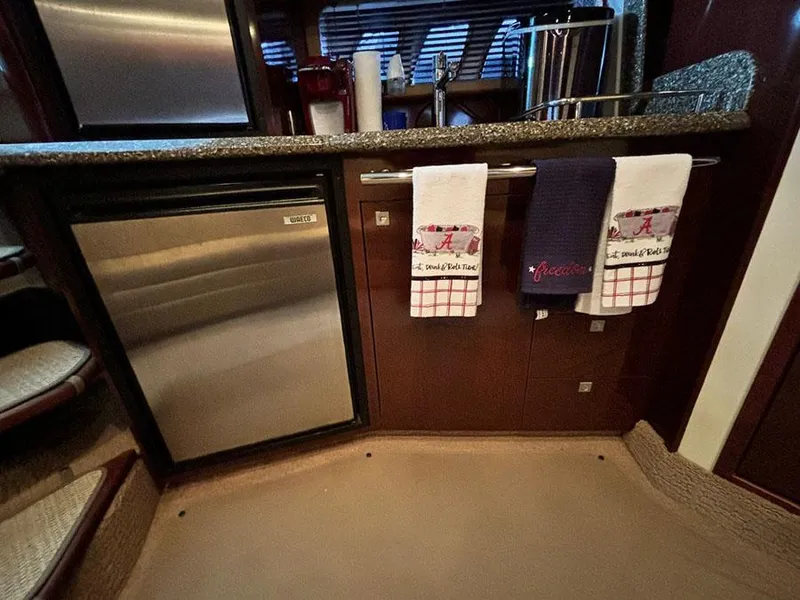 Slide: The Image of Interior of 2008 Sea Ray 38 Sundancer with kitchen area and stainless steel appliances. - 24