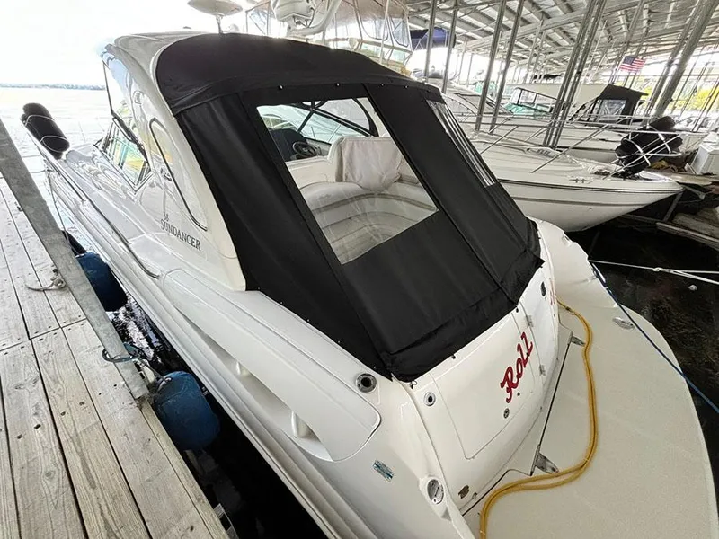 Slide: The Image of 2008 Sea Ray 38 Sundancer docked, featuring a sleek design and black canopy. - 4