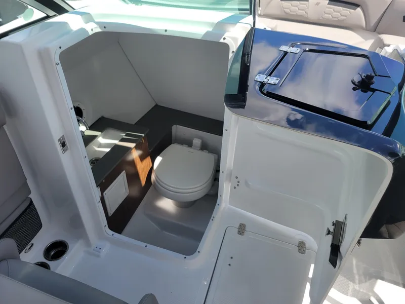 Slide: The Image of 2024 Four Winns HD5 OB boat interior with a compact marine toilet. - 15