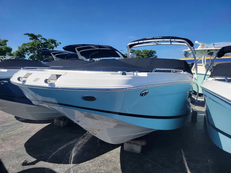 Slide: The Image of 2024 Four Winns HD5 OB boat in a marina, blue and white exterior. - 17