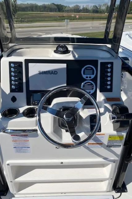 Slide: The Image of 2024 Robalo R222 Center Console boat dashboard with Simrad display. - 2