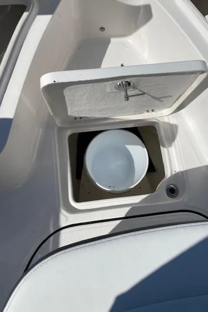 Slide: The Image of 2024 Robalo R222 Center Console storage compartment with white bucket. - 10