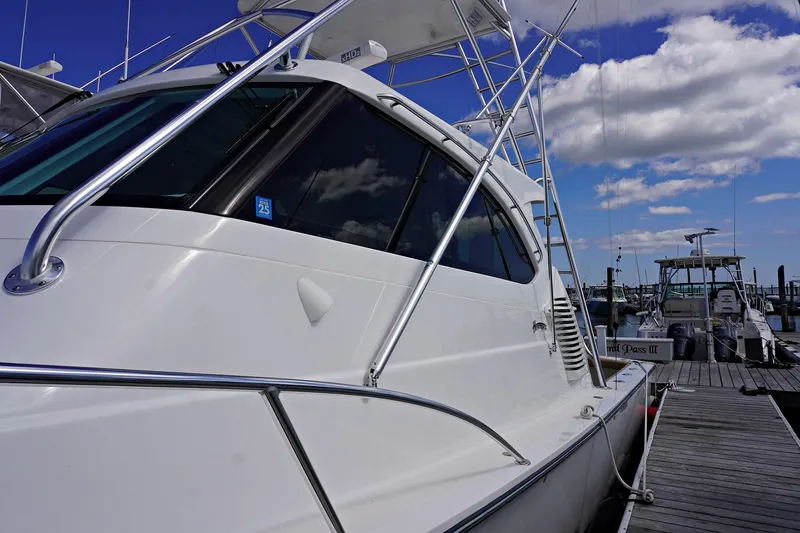 Slide: The Image of 2022 Henriques 42EXHT boat docked at a marina under a blue sky. - 10