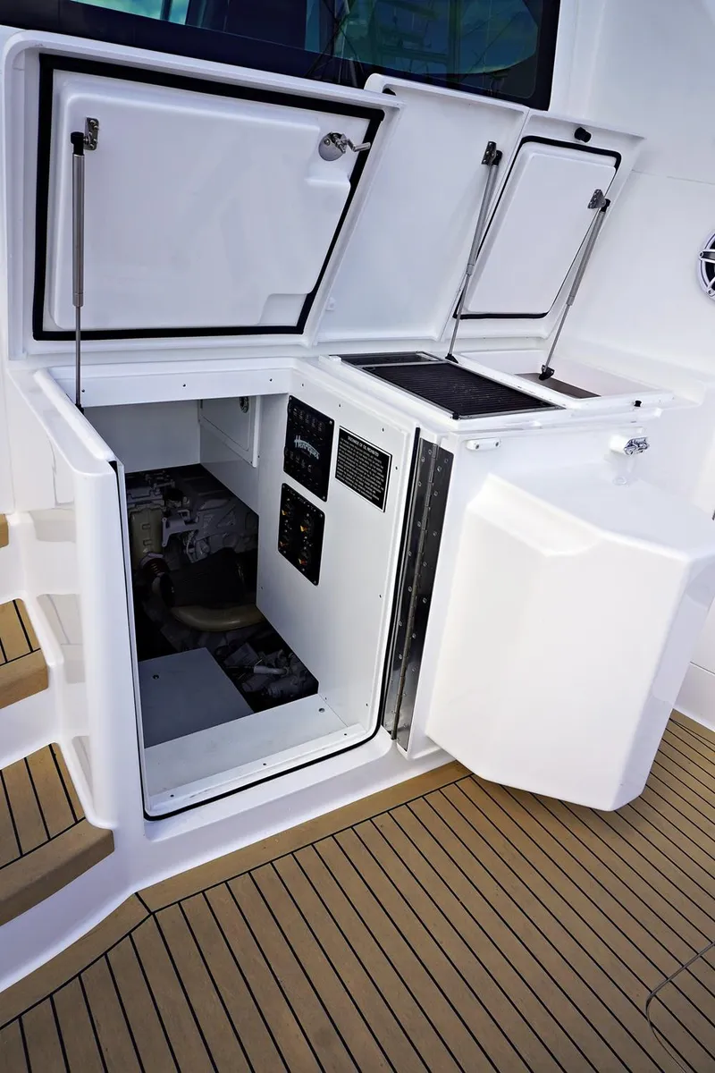 Slide: The Image of Henriques 42EXHT 2022 model boat with open storage compartments and teak flooring. - 22