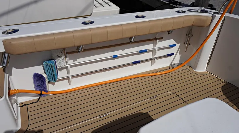 Slide: The Image of Henriques 42EXHT 2022 boat deck with fishing rod holders and cleaning supplies. - 23