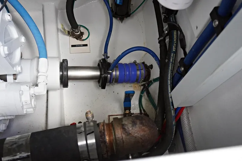 Slide: The Image of Engine compartment of 2022 Henriques 42EXHT boat, featuring various hoses and mechanical components. - 27