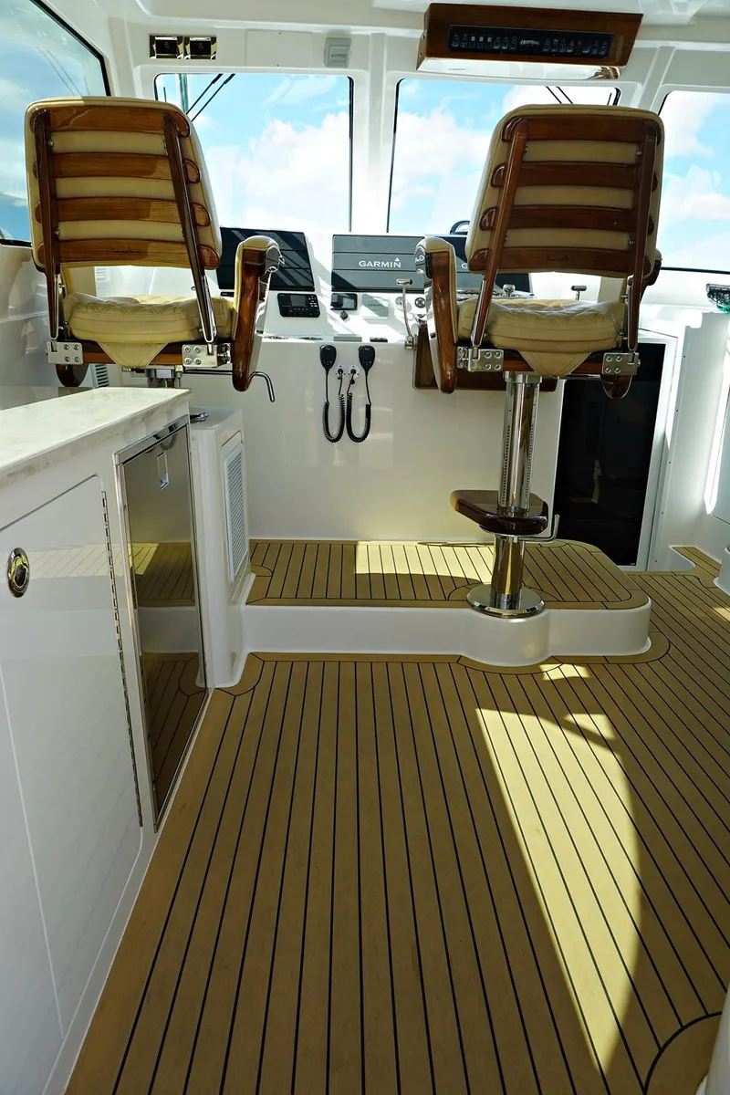 Slide: The Image of 2022 Henriques 42EXHT boat interior with wooden flooring and captain's chairs. - 36