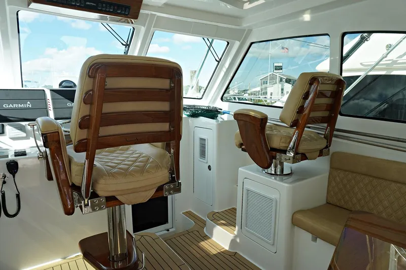 Slide: The Image of Interior of 2022 Henriques 42EXHT boat with captain's chairs and navigation equipment. - 41