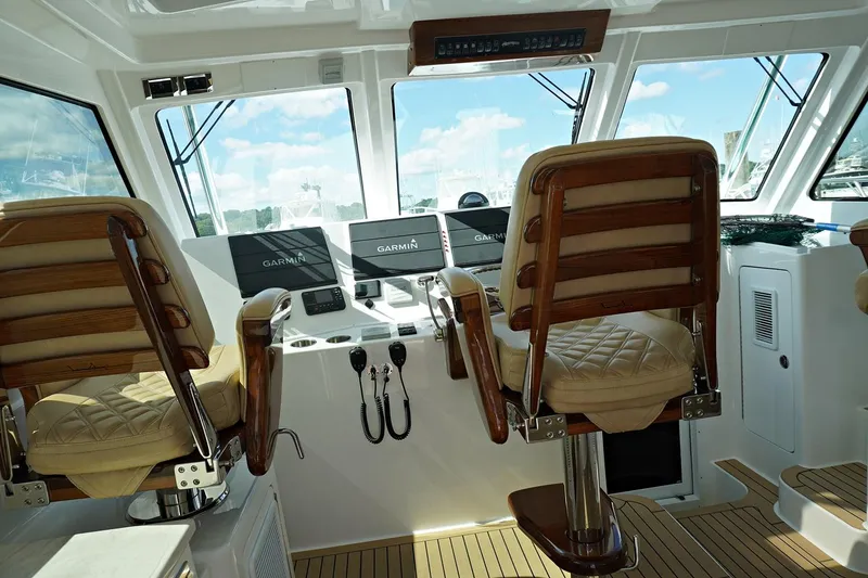 Slide: The Image of Helm station of 2022 Henriques 42EXHT with dual captain chairs and Garmin electronics. - 42