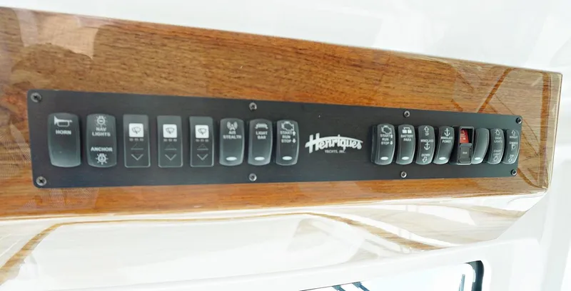 Slide: The Image of Control panel of a 2022 Henriques 42EXHT boat with various switches. - 48