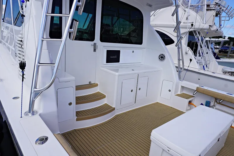 Slide: The Image of 2022 Henriques 42EXHT boat deck with seating, storage, and ladder. - 9