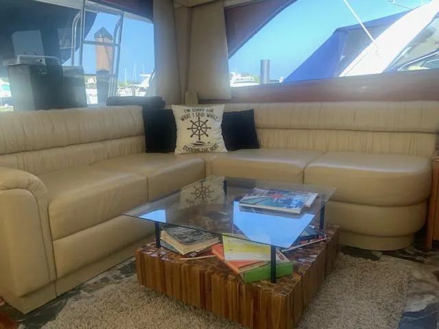 Slide: The Image of Luxurious interior of 2002 Viking 55 Convertible yacht with beige leather seating and glass table. - 2