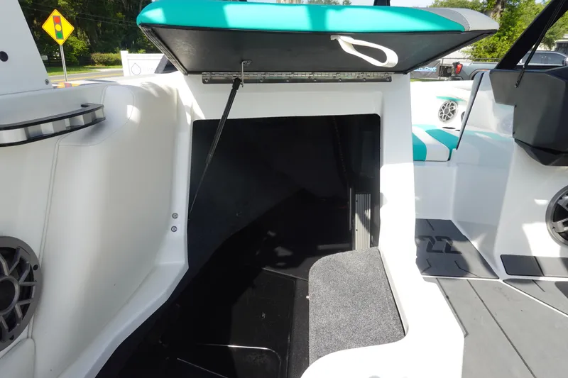 Slide: The Image of 2020 Axis T22 boat interior storage compartment with open hatch and teal seating. - 19