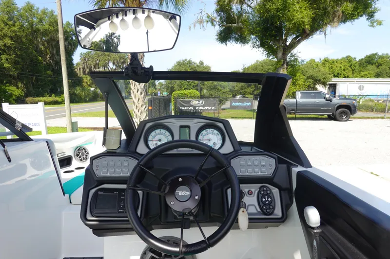 Slide: The Image of 2020 Axis T22 boat dashboard with steering wheel and gauges, outdoor setting. - 22