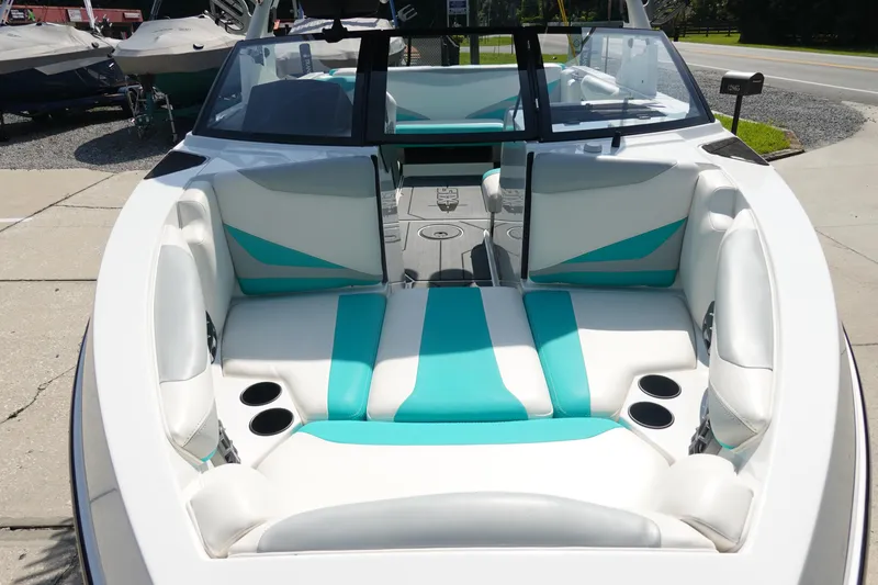 Slide: The Image of 2020 Axis T22 boat interior with white and teal seating, cup holders, and windshield. - 34
