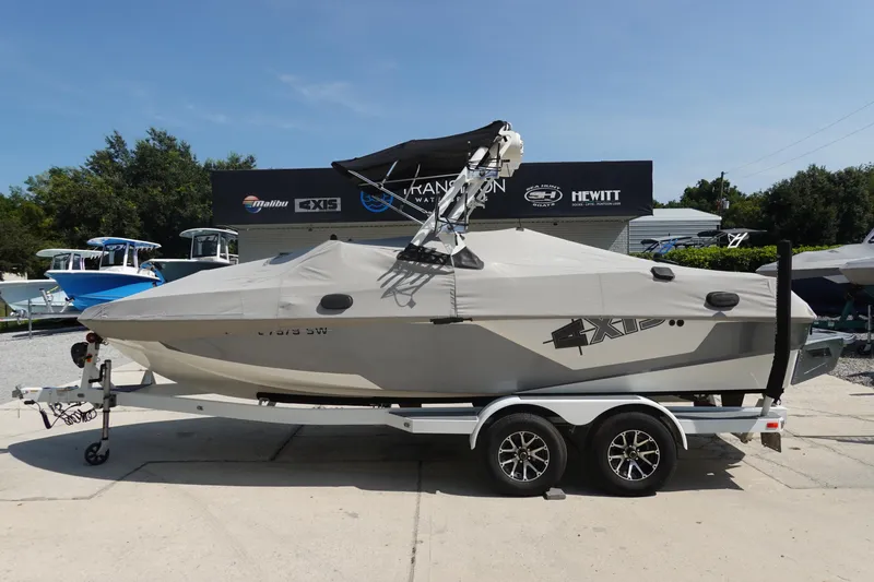 Slide: The Image of 2020 Axis T22 boat on trailer, covered, parked outdoors at dealership. - 48