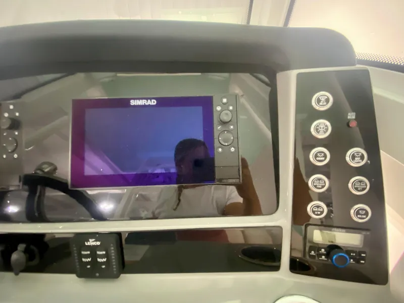 Slide: The Image of 2024 Robalo R270 boat dashboard with Simrad display and control panel. - 21