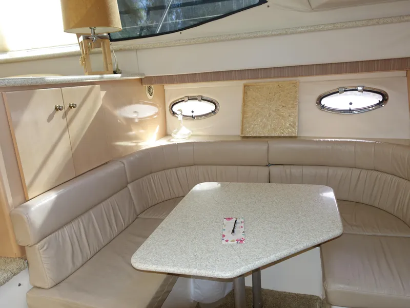 Slide: The Image of 2000 Carver 406 Aft Cabin Motor Yacht interior with beige seating and table. - 11
