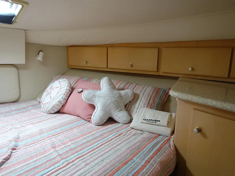 Slide: The Image of Cozy bedroom in 2000 Carver 406 Aft Cabin Motor Yacht with striped bedding and decorative pillows. - 16