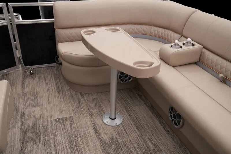 Slide: The Image of 2024 Ranger Reata 220C interior with beige seating and table, featuring cup holders. - 39