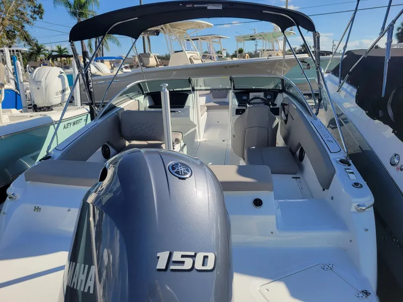 Slide: The Image of 2024 Four Winns H1 OB boat with Yamaha 150 outboard motor, docked in marina. - 10