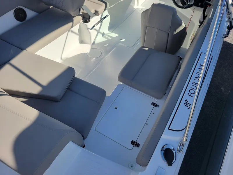 Slide: The Image of 2024 Four Winns H1 OB boat interior with gray seating and white deck. - 13